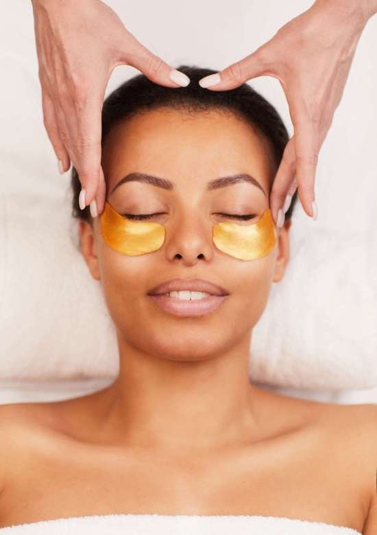 Above view portrait of beautiful mixed race woman enjoying facial therapy in luxury spa, copy space